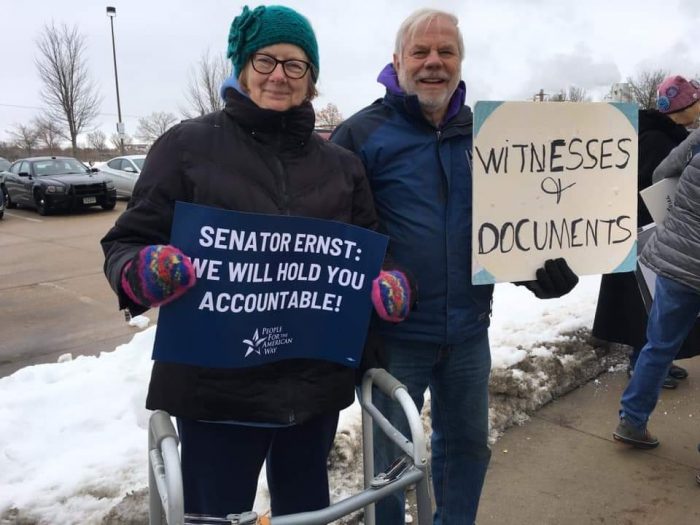 Two PFAW supporters hold signs outside of Rep. Sen. Joni Ernst's office in Cedar Rapids
