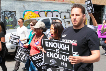 Svante Myrick marches with Young Elected Officials holding a sign that reads "Enough is Enough"